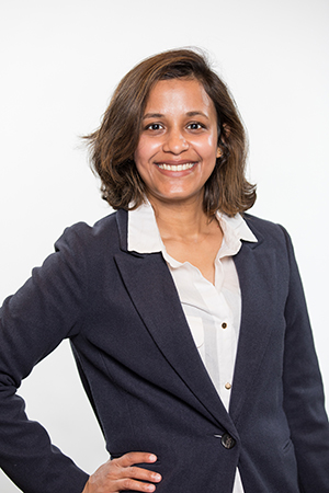 Headshot of Rupsa Bhattacharjee, PhD wearing a shite button up shirt and a grey blazer against a white background