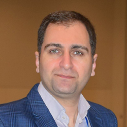 Mansour Abtahi wearing a blue blazer and light-colored shirt, looking at the camera against a neutral indoor background.